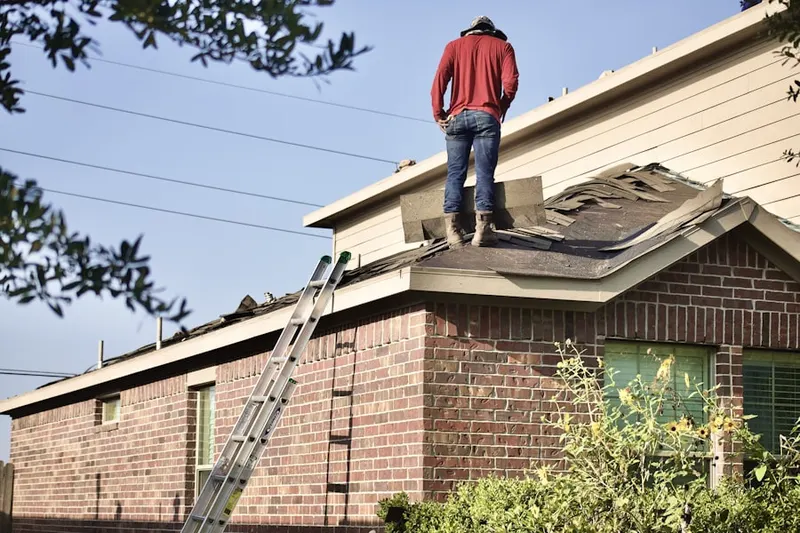 Professional roofer working on a residential roof in Harlem Heights